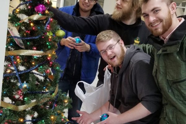 Brothers Alex Denton, Max Green, Zach Brown, and Conner Loveless posing for a photo after putting together our Christmas tree for Trine this year!